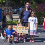 Francisco Garcia, son Nicolas and daughters Josie (seated) and Amaya (standing) display the signs the kids made before the march and car caravan. Along with wife Jennifer McInnis is Amanda McCarthy, both on Community Action Marin's Board.