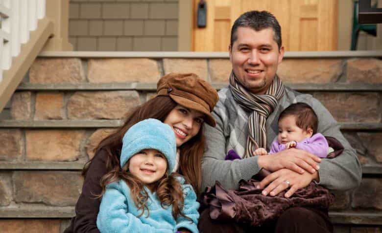 Family sitting on steps and smiling